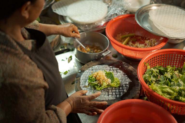 Local street food vendor preparing fresh Cambodian spring rolls in Siem Reap