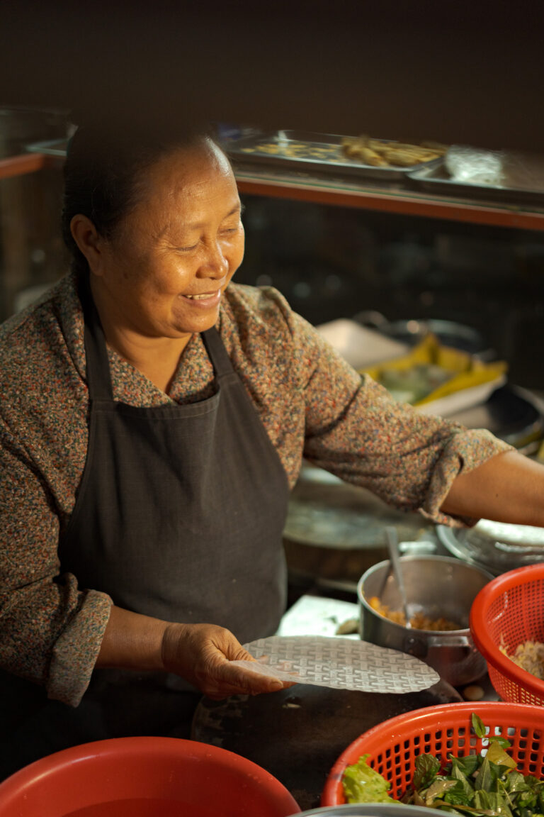 Local Cambodian street food vendor preparing fresh spring rolls in Siem Reap